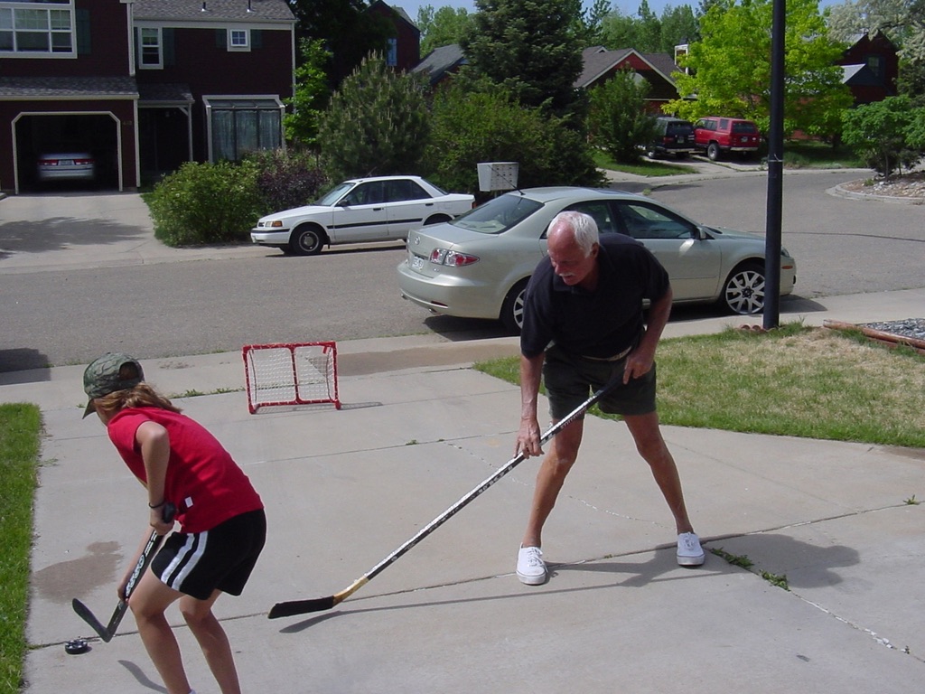 Marshall playing driveway hockey with a young family member