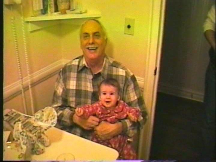 A smiling Marshall holding a baby in his lap