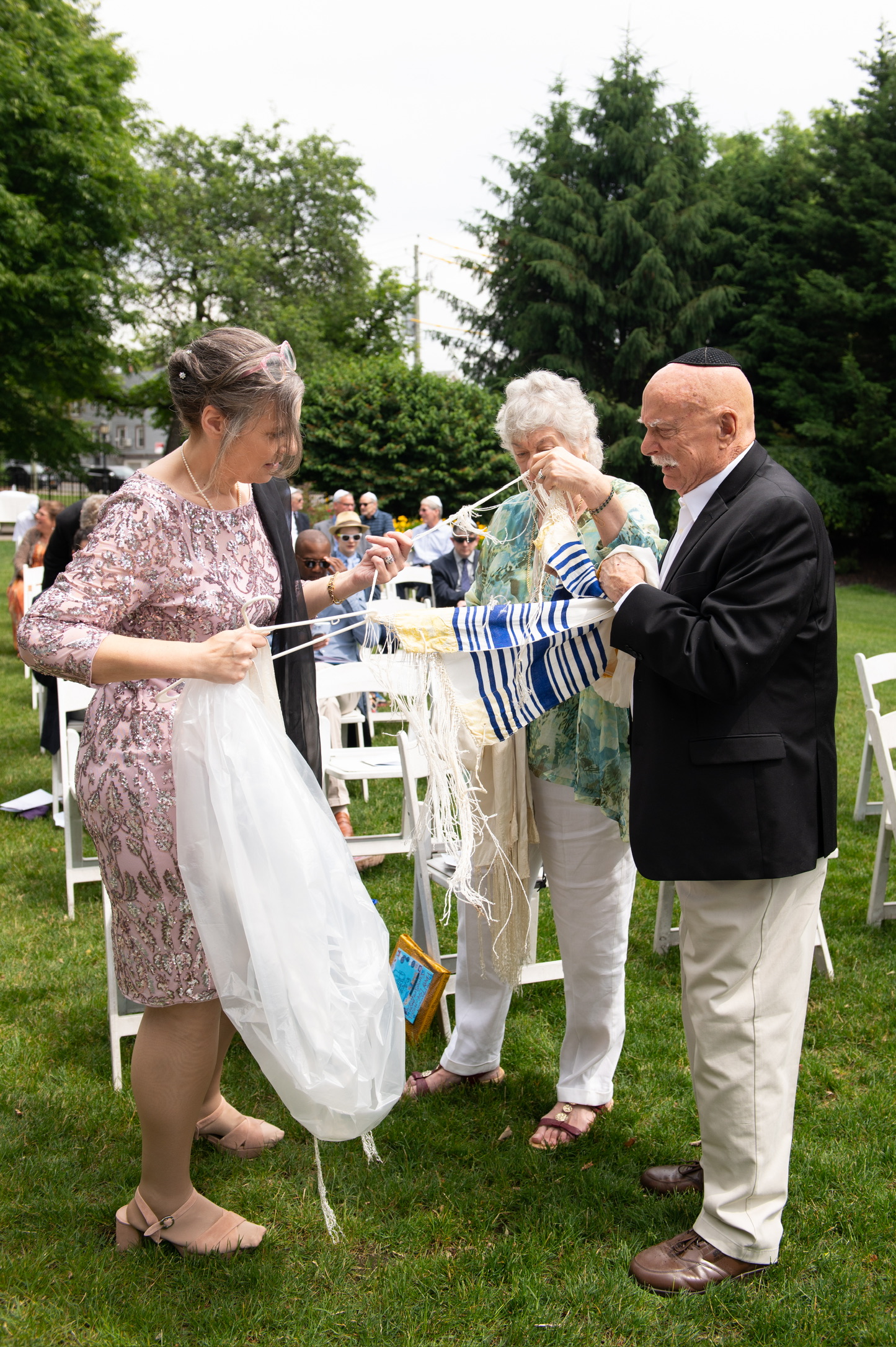 Marshall and Marian helping prepare a tallit during a family ceremony