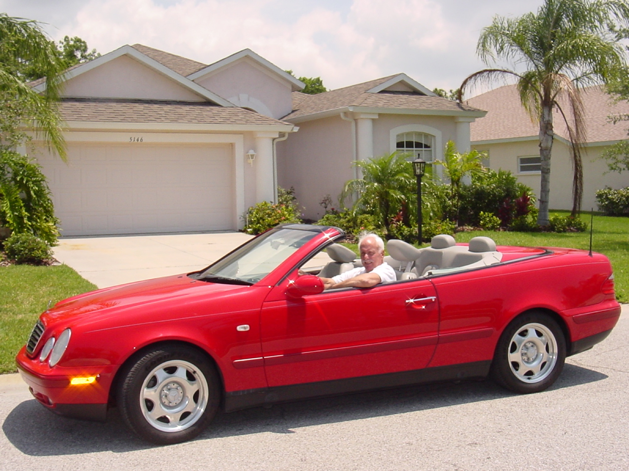 Marshall behind the wheel of a bright red convertible